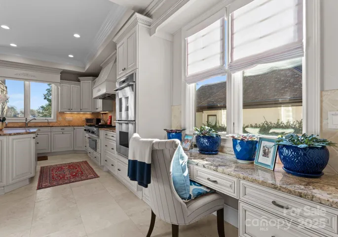 This thoughtfully designed area, seamlessly integrated into the kitchen, features a built-in desk, offering a perfect space for work or organization while maintaining an open, connected feel to the heart of the home.