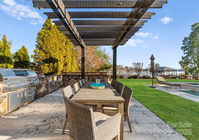 A refined outdoor cooking retreat, this grilling area boasts high-performance burners, ample prep space, and a built-in beverage cooler, all beneath a charming pergola for effortless entertaining.