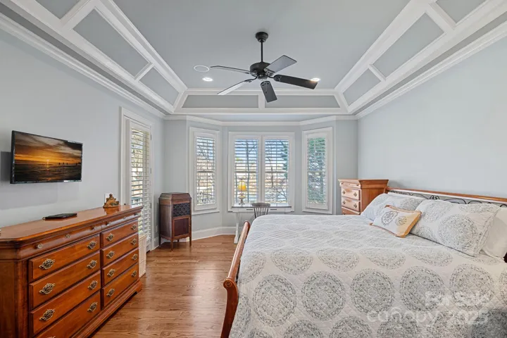 Primary bedroom with lake views and beautiful, custom architectural details, and access to covered balcony
