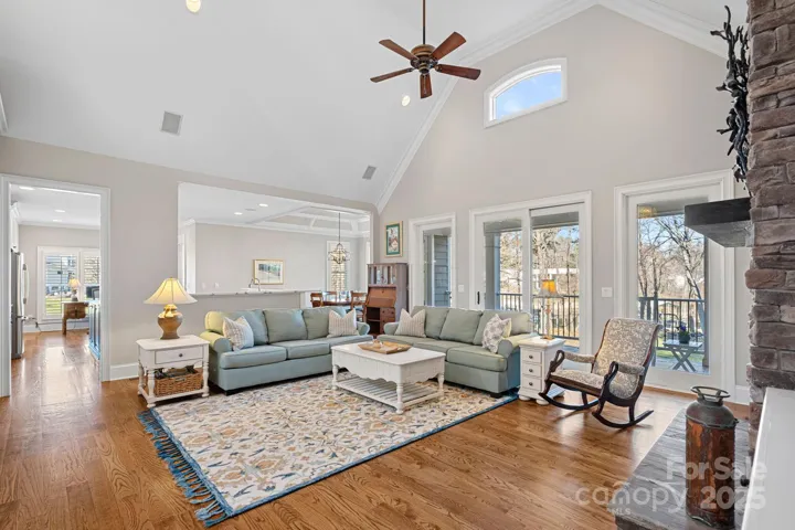 Stunning living room with vaulted ceiling, full-height stone fireplace, built-ins, and lake views!