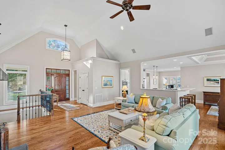 Stunning living room with vaulted ceiling, full-height stone fireplace, built-ins, and lake views!