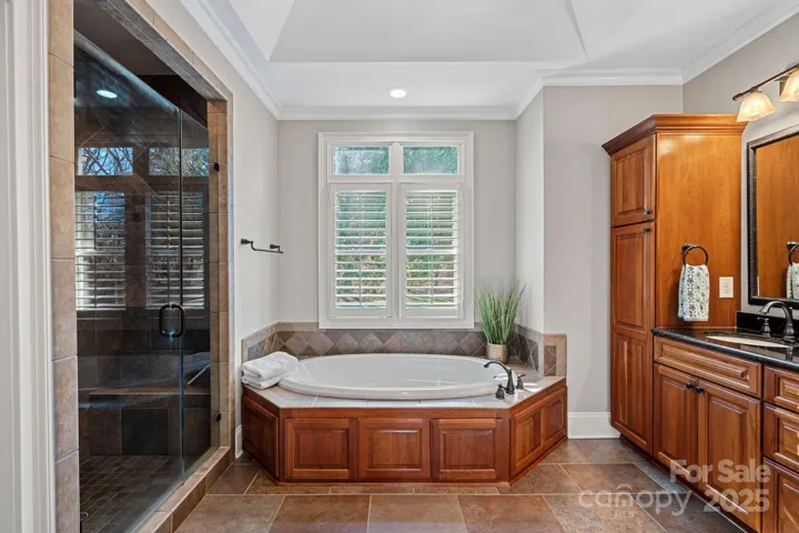 Primary ensuite with large, walk-in shower, garden tub, beautiful custom cabinetry
