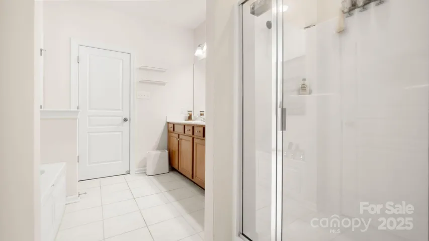 Spacious primary ensuite with double sinks, separate jetted tub and walk in shower