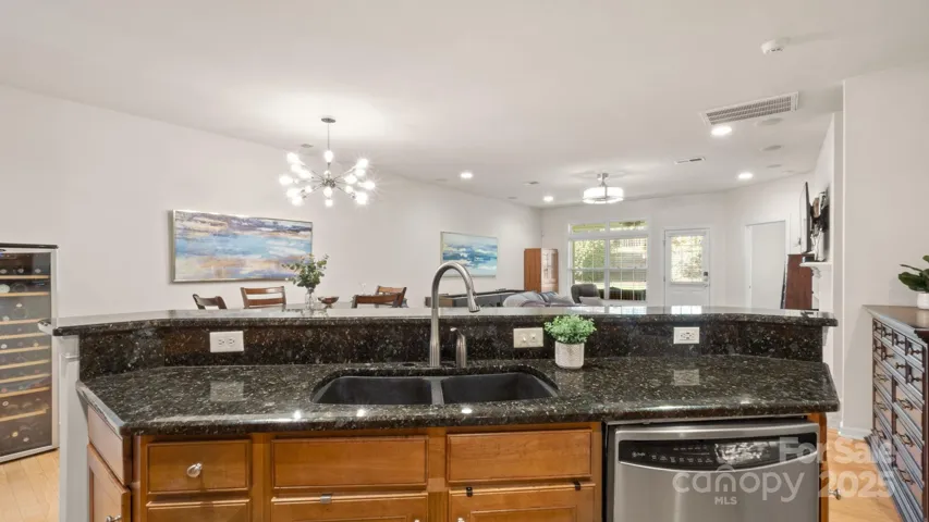 Huge kitchen island with sparkling granite overlooks the broad open concept living & dining spaces