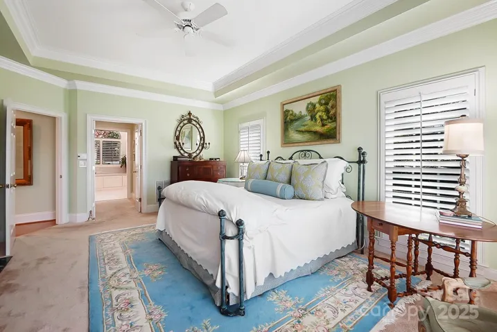 Wake up to the serene beauty of the lake from the luxurious primary suite on the main floor boasting tray ceilings, sitting area, fireplace, and 2 walk-in closets