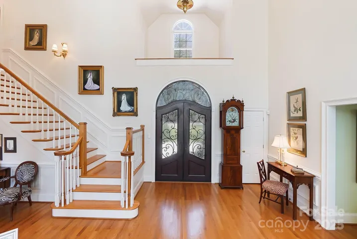 The grand foyer welcomes you into a soaring two-story great room, where a fireplace and built-in cabinetry create a warm and inviting ambiance