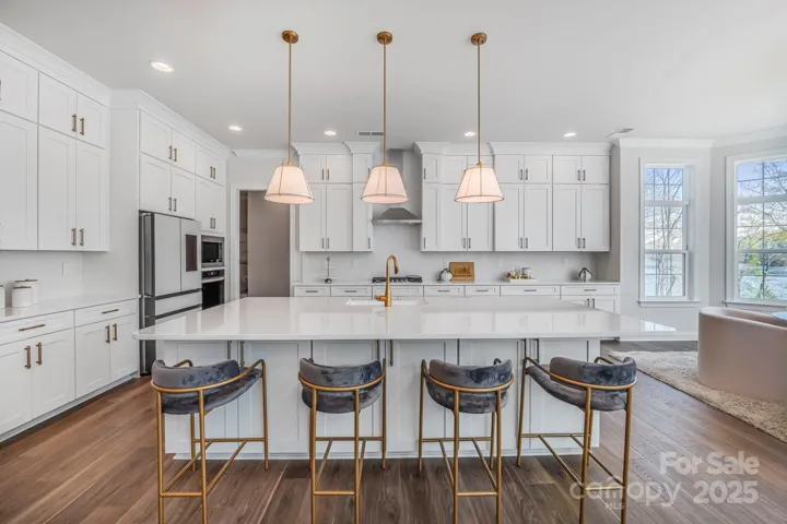 Large kitchen island ideal for entertaining, with pendant lighting and seating for four.