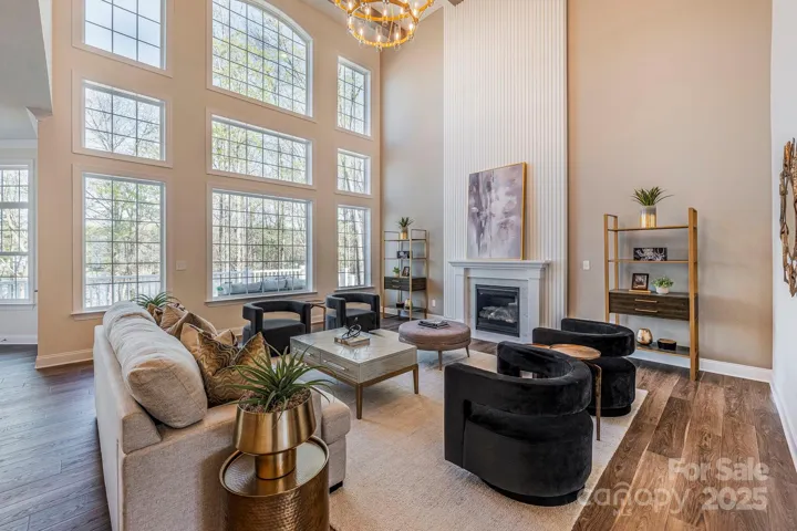 Grand foyer with two-story ceilings, crown molding, and a custom fireplace centerpiece.