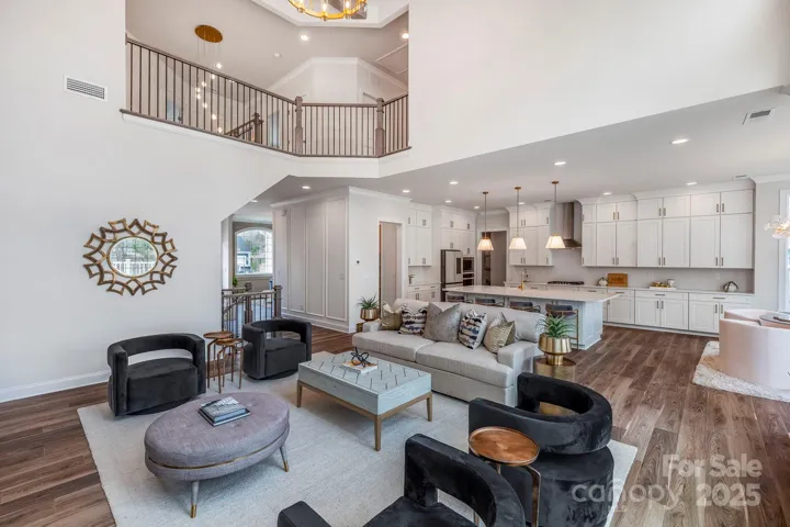 Two-story foyer with a view of the main living area and decorative chandelier.