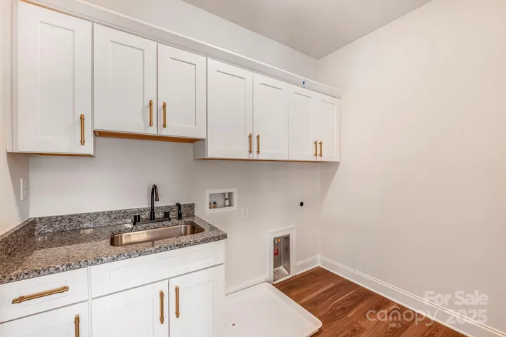 Laundry with built-in storage and washer/dryer setup.