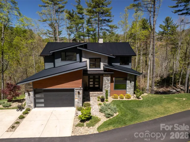 Welcome to 42 Spring Cove Rd in prestigious Grove Park Cove! Enjoy the incredible seasonal views from this amazing custom built home. Built in 2022, this stunning mountain modern home is located in North Asheville's coveted Grove Park Cove. Just a short 5 minute drive to downtown Asheville, you're close to everything - shopping, fine dining, entertainment, Beaver Lake, and more!  This home features nearly 4200 square feet of luxury living all set within a lush natural setting with incredible treed and seasonal mountain views!