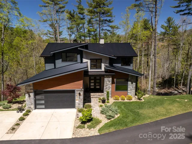 Welcome to 42 Spring Cove Rd in prestigious Grove Park Cove! Enjoy the incredible seasonal views from this amazing custom built home. Built in 2022, this stunning mountain modern home is located in North Asheville's coveted Grove Park Cove. Just a short 5 minute drive to downtown Asheville, you're close to everything - shopping, fine dining, entertainment, Beaver Lake, and more!  This home features nearly 4200 square feet of luxury living all set within a lush natural setting with incredible treed and seasonal mountain views!