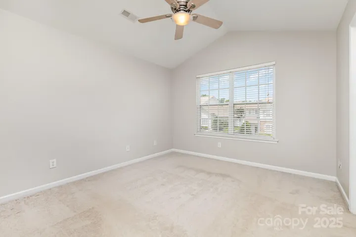 Vaulted ceiling in primary bedroom gives character and interest.