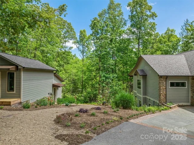 Beautiful flower beds and stone paths between storage shed and house