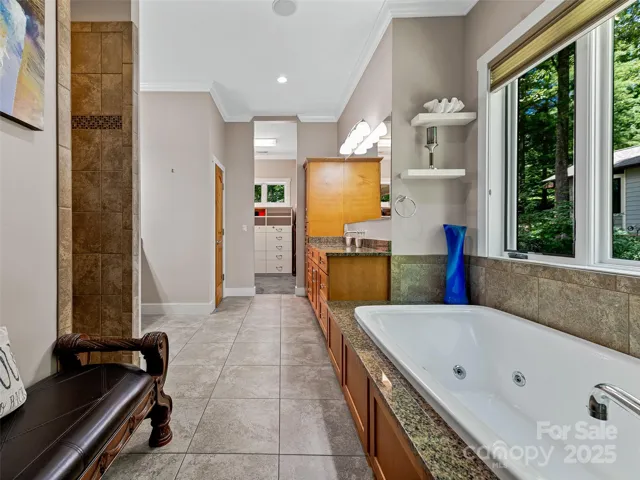 Primary Bathroom features a Kohler whirlpool tub, walk-in shower and radiant tile floor