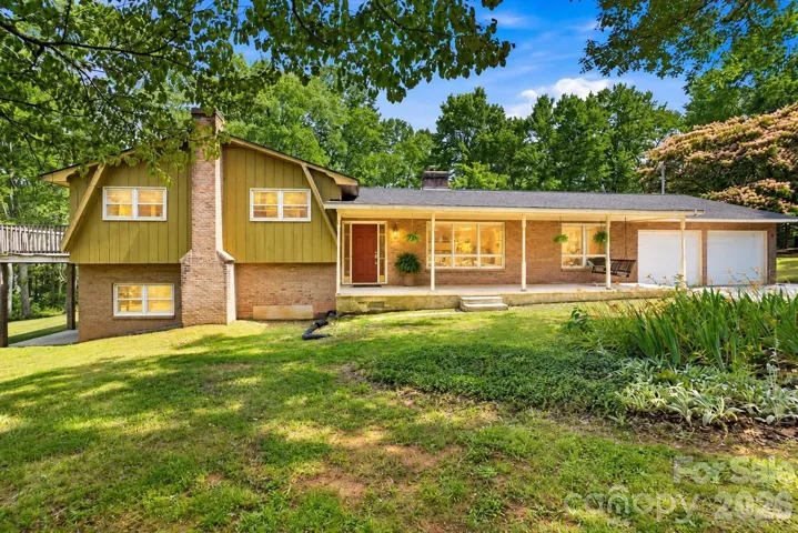 Relax, unwind, and enjoy the view from the front porch of this inviting split-level home. Virtually enhanced twilight image.