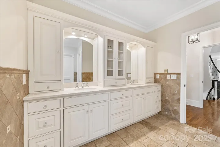 The primary bath boasts travertine tile, beautiful cabinetry, and instantly on hot water.