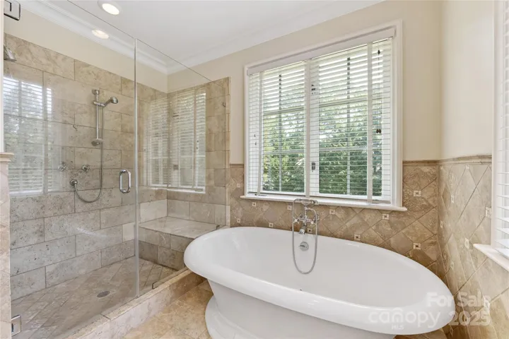 A gorgeous soaking tub and frameless glass & tile shower are highlights of this lovely bathroom.