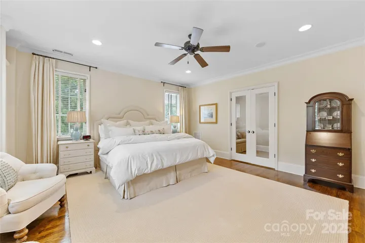 The primary suite features custom built-ins, a French door entry into a small sitting room, office, or exercise space & a huge walk-in closet with custom built-ins as well.