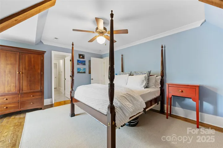 Bedroom 6 is on the third floor. It features some wood beams as part of its sloped ceiling.