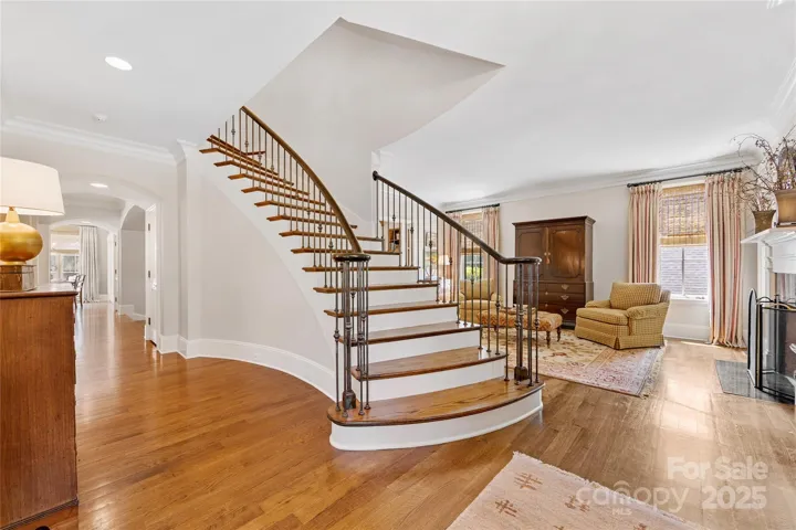 An elegant turned staircase with iron balusters leads to the second floor.