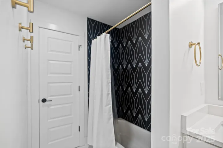 Full hallway bathroom with tub & fun hexagon tile!