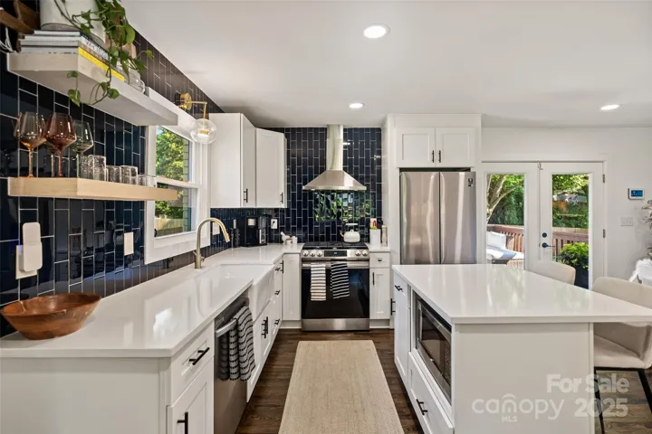Floating shelves with a counter to ceiling vertically laid tile backsplash!