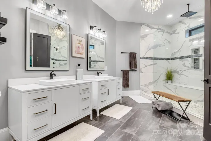 Primary en-suite has dual vanities, oversized custom marble shower w/bench and laundry hookup.