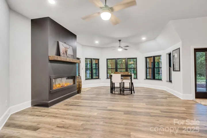 Spacious rec room with electric fireplace insert, provides dual access to the backyard.