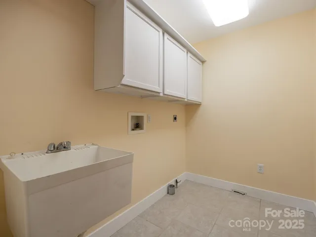 Laundry room with storage, laundry sink, and floor drain.