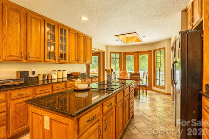 View of light filled kitchen looking out onto the back deck