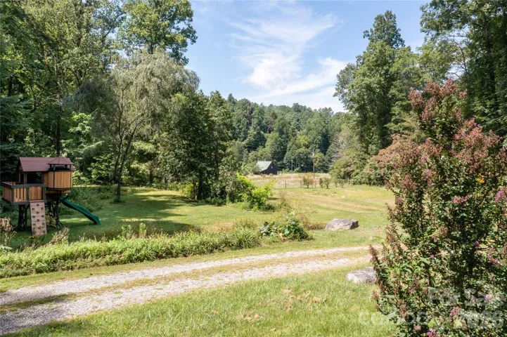 View from in front of garage overlooking the pasture - pond located just past the playset