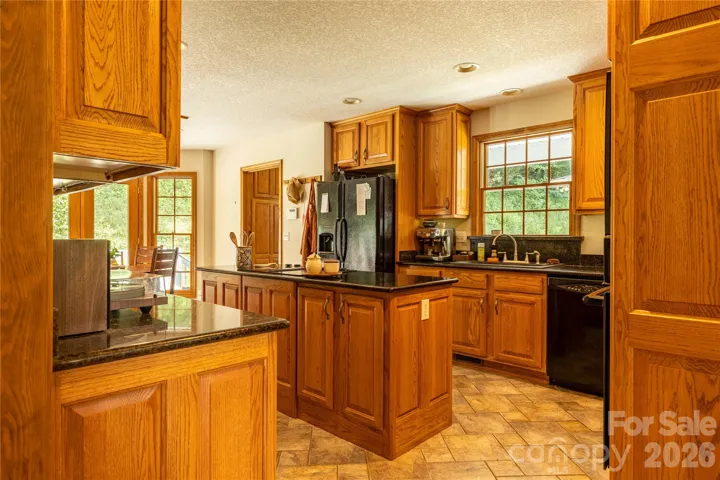 Spacious kitchen with granite countertops, island, and tiled floor