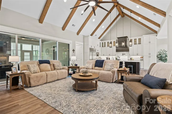 Great Room with wood beams and large 10-blade ceiling fan.