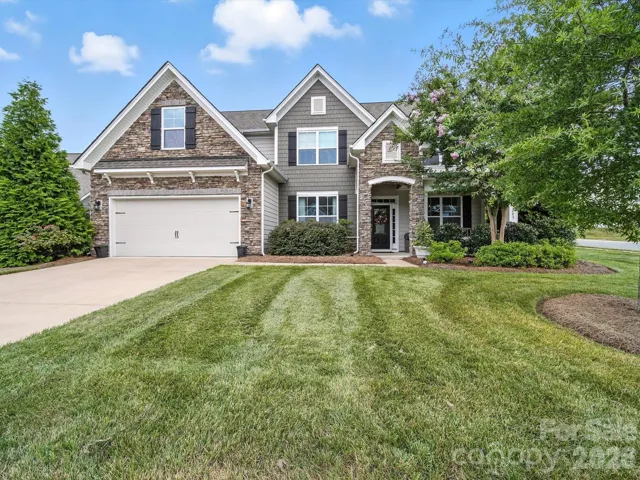 Beautiful former model home with brick accents and landscaped front yard.