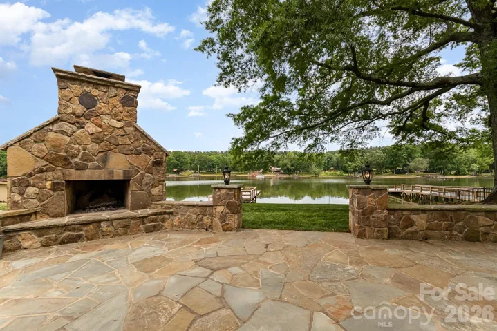 Large stone patio with electricity and oversized fireplace that overlooks High Rock Lake, private pier and boat dock