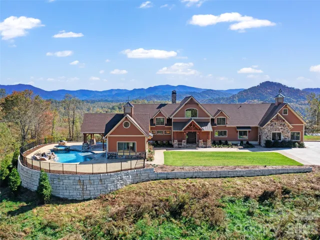 FRONT ELEVATION OF HOME AND POOL - BEAUTIFUL FRONT DOOR- ROCK WALLS - BEAUTIFUL GREEN SPACE AND LOTS OF INCREDIBLE LANDSCAPING