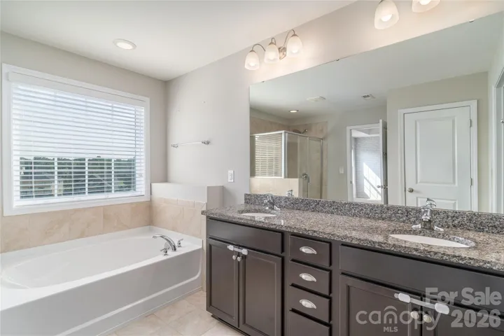 Dual granite vanity in the primary bathroom
