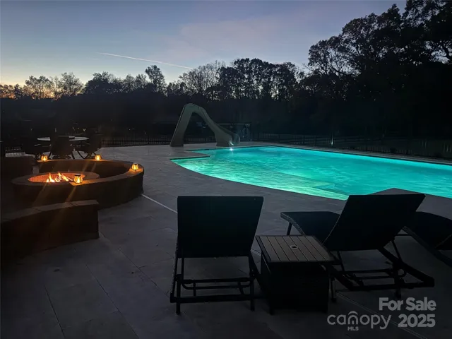Nightime pool lights and wood firepit with gas starter