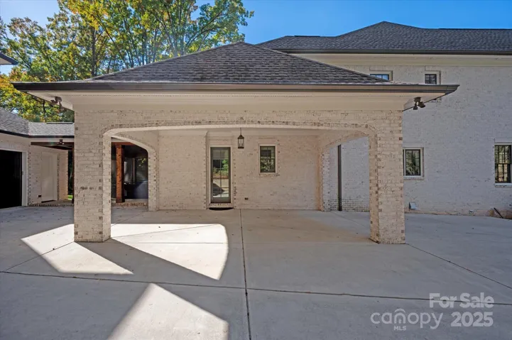 porte cochère + covered breezeway connecting the main home and guest space.