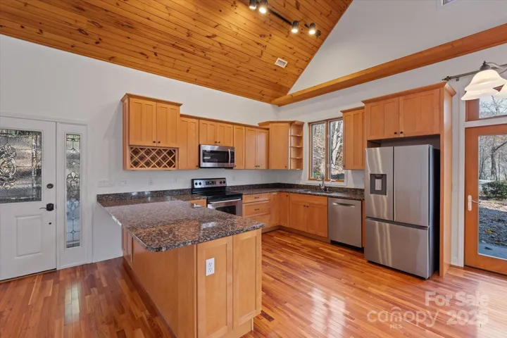 Wood cabinets, granite counters, and an open flow make this kitchen ready for entertaining!