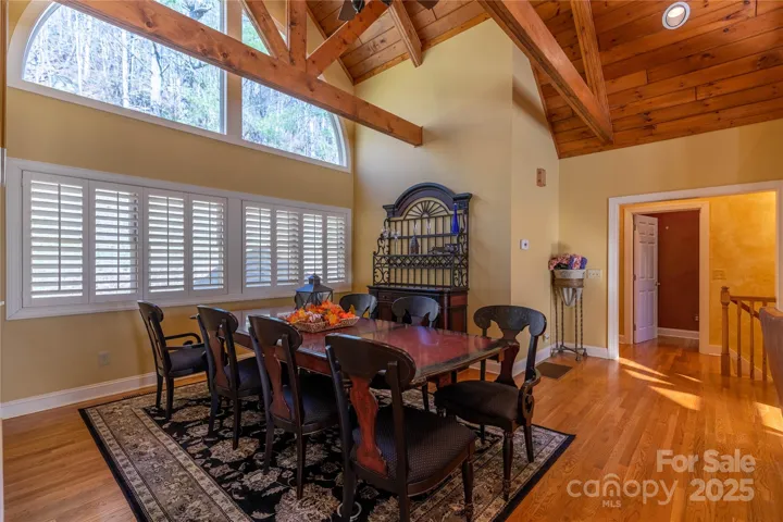 Formal dining can accommodate seating for 8 and flanked by wall of windows with plantation shutters and huge paladium window above