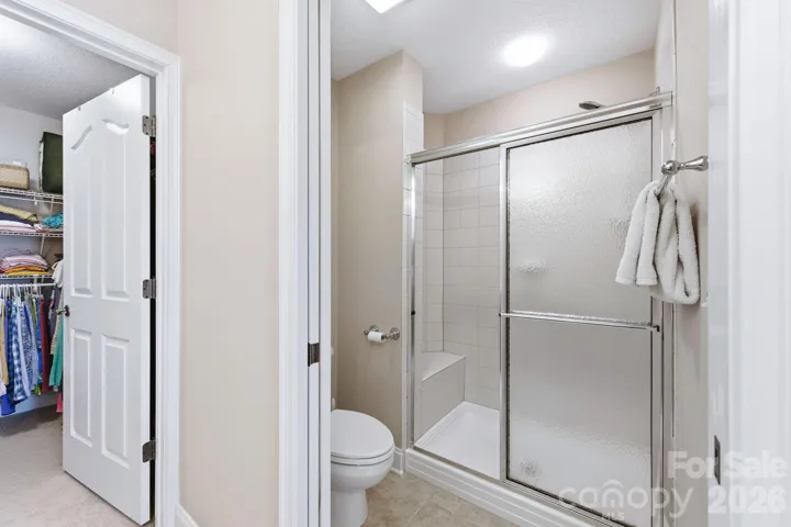 Primary ensuite has privacy toilet and shower with a sitting area