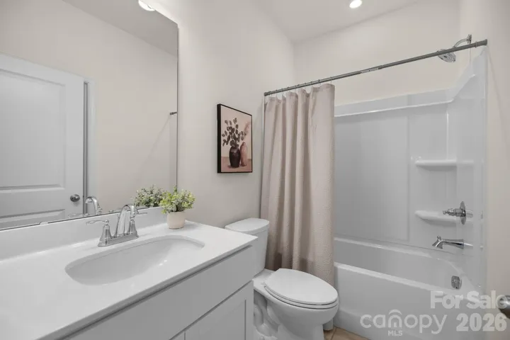 Full ensuite bath with clean lines and modern finishes serves the guest suite beautifully.