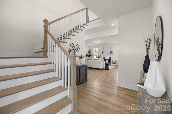 Bright, welcoming foyer with wide-plank floors and an open sightline to the main living spaces sets an elegant first impression.