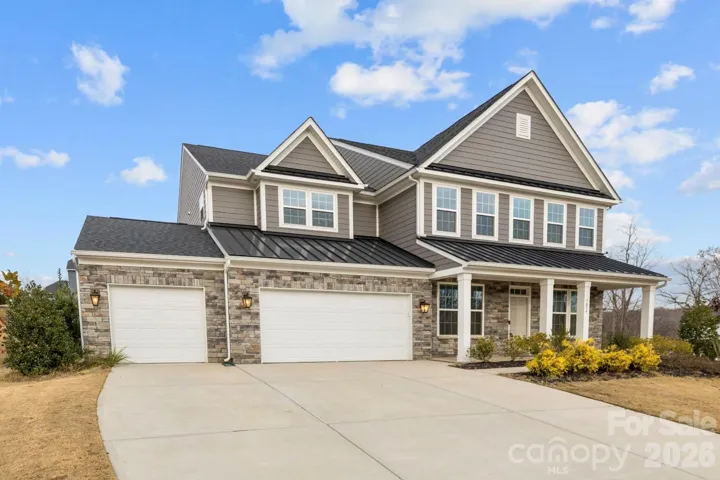 Striking curb appeal, transitional design, stone accents, and a charming front porch on a desirable corner lot with peek-a-boo views of Lake Wylie.