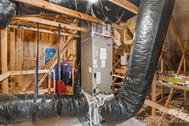 Walk in lighted attic with extra flooring past mechanicals