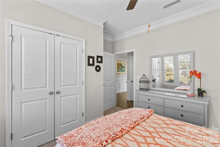 Front bedroom with crown molding, large customized closet