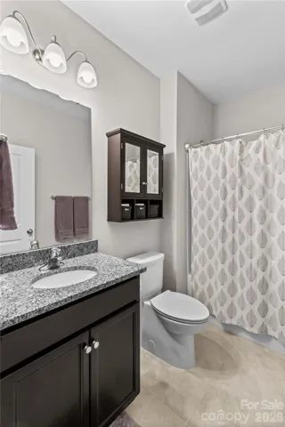 Full bath on main with tile flooring, comfort height toilets, ebony cabinets