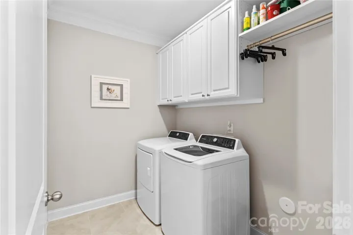 Laundry on main with tile floors, cabinets and hang dry area